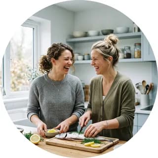 Due amiche preparano del pesce in cucina